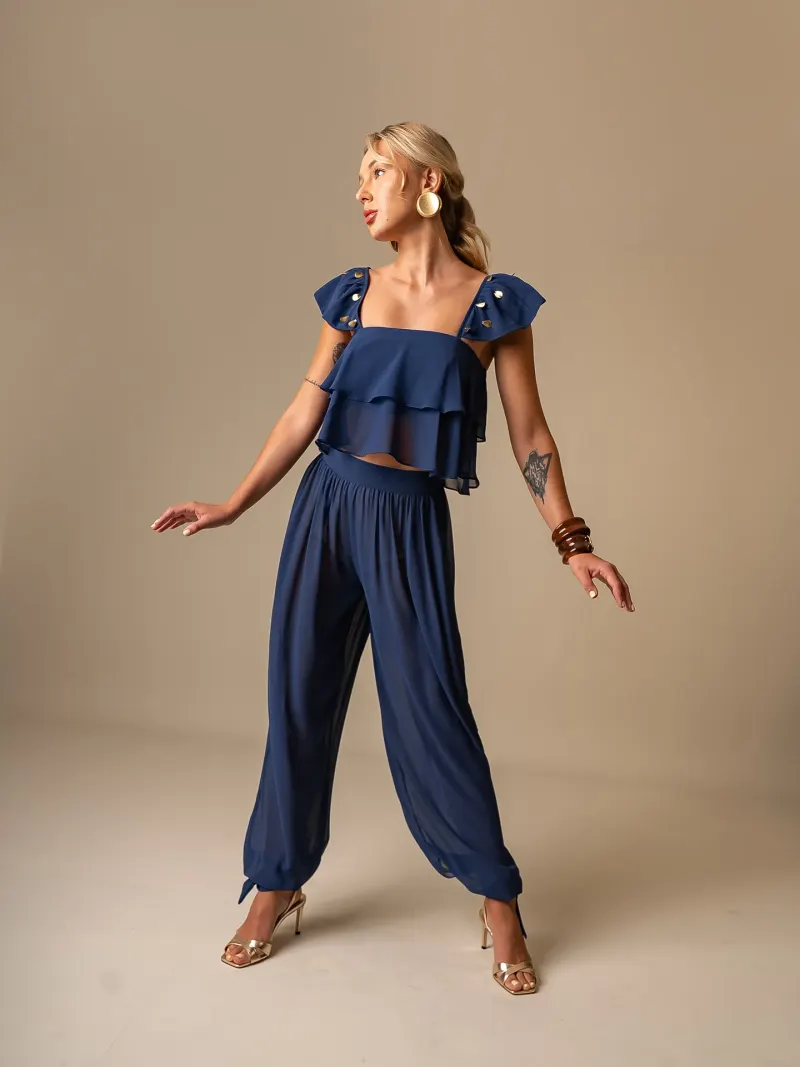 Modelo com conjunto azul-marinho em pose de movimento